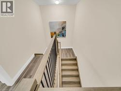 Staircase with wood finished floors and baseboards - 