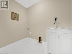 Laundry room with baseboards and marble look tiles - 