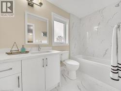 Bathroom featuring vanity, a combined bath / shower with marble appearance, and light marble finish flooring - 