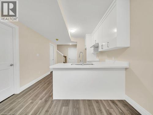 Kitchen with white cabinets, light wood-style flooring, and a peninsula - 256 W King Street, Ingersoll, ON - Indoor