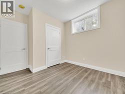 Unfurnished bedroom with baseboards and light wood-style flooring - 