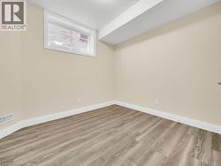 Basement with light wood-style flooring and a textured ceiling - 