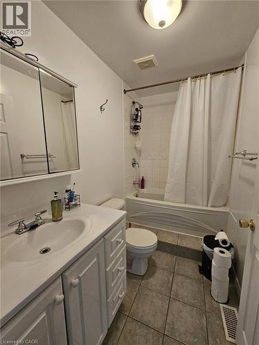 Full bath featuring shower / tub combo with curtain, vanity, and dark tile patterned flooring - 253 Mary Street, Hamilton, ON - Indoor Photo Showing Bathroom