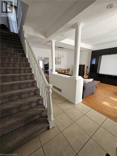 Stairway with tile patterned flooring, a raised ceiling, and ornate columns - 253 Mary Street, Hamilton, ON - Indoor Photo Showing Other Room