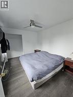 Bedroom featuring dark wood-type flooring, a ceiling fan, and a closet - 
