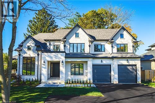 French country inspired facade with a garage, asphalt driveway, and stone siding - 362 Harmony Hall Drive, Ancaster, ON - Outdoor With Facade