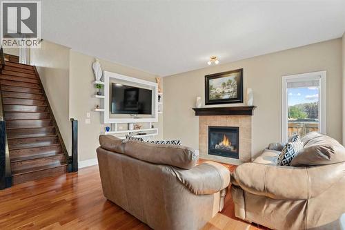Custom wall shelving - 113 Aspen Stone Place Sw, Calgary, AB - Indoor Photo Showing Living Room With Fireplace