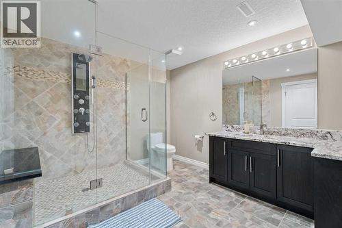 The bathroom has a luxury shower system with numerous jets and a big bench to relax on - 113 Aspen Stone Place Sw, Calgary, AB - Indoor Photo Showing Bathroom