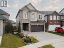 View of front of property with stone siding, driveway, a front yard, stucco siding, and a garage - 346 Moorlands Crescent, Kitchener, ON  - Outdoor With Facade 