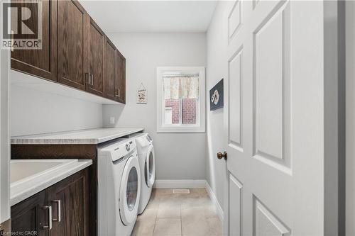 Laundry room featuring light tile patterned floors, cabinet space, and separate washer and dryer - 346 Moorlands Crescent, Kitchener, ON - Indoor Photo Showing Laundry Room