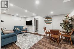 Living room with dark wood-style flooring and recessed lighting - 