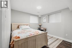 Bedroom featuring wood finished floors and baseboards - 