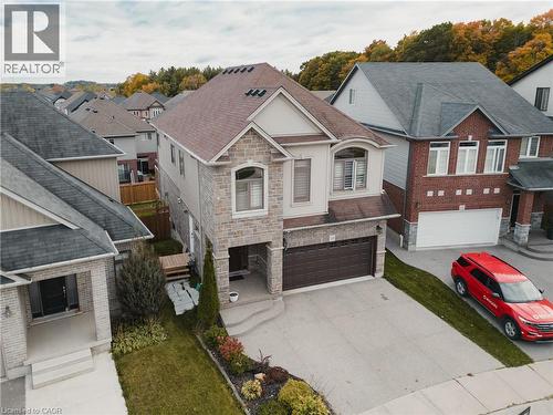 View of front facade with a residential view, stone siding, driveway, and a garage - 346 Moorlands Crescent, Kitchener, ON - Outdoor With Facade