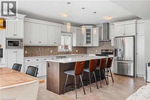 Kitchen with appliances with stainless steel finishes, a kitchen bar, a kitchen island, wall chimney range hood, and backsplash - 346 Moorlands Crescent, Kitchener, ON - Indoor Photo Showing Kitchen With Stainless Steel Kitchen With Upgraded Kitchen