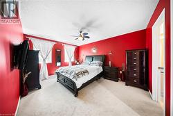 Bedroom featuring a textured ceiling, light colored carpet, and ceiling fan - 