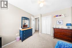 Bedroom with light colored carpet, a ceiling fan, and a closet - 