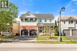 View of front of home with driveway, brick siding, covered porch, and a garage - 