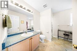 Bathroom with vanity, a shower with curtain, and light stone finish flooring - 