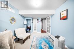 Living area with french doors, a textured ceiling, and carpet flooring - 