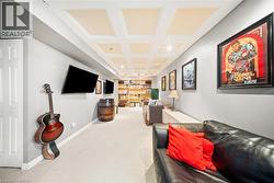 Carpeted living room featuring coffered ceiling and beamed ceiling - 