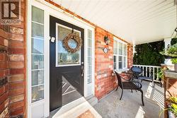 Property entrance featuring a porch and brick siding - 
