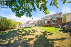 Fenced backyard with a trampoline, a playground, and a deck - 