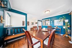 Dining space featuring dark wood-style floors and crown molding - 
