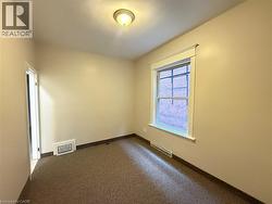 Empty room with dark colored carpet and baseboards - 