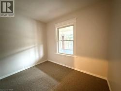 Carpeted empty room featuring baseboards - 