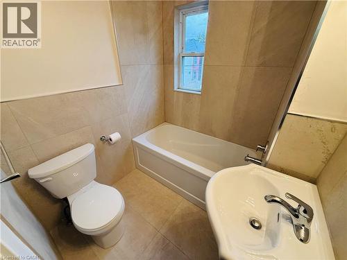 Bathroom featuring tile walls, a garden tub, and tile patterned floors - 24 Somerset Avenue, Hamilton, ON - Indoor Photo Showing Bathroom