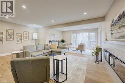 Living room featuring light wood finished floors, a multi sided fireplace, and recessed lighting - 