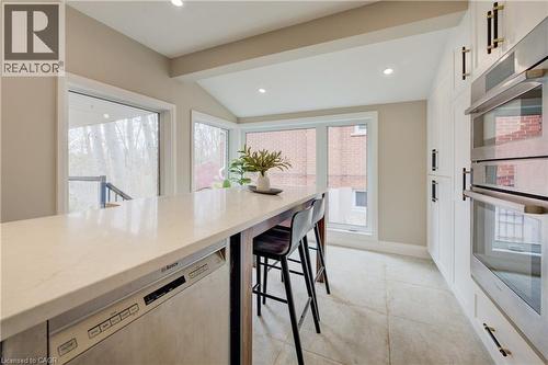 Kitchen featuring stainless steel appliances, light stone counters, vaulted ceiling, recessed lighting, and plenty of natural light - 279 Ferndale Place, Waterloo, ON - Indoor