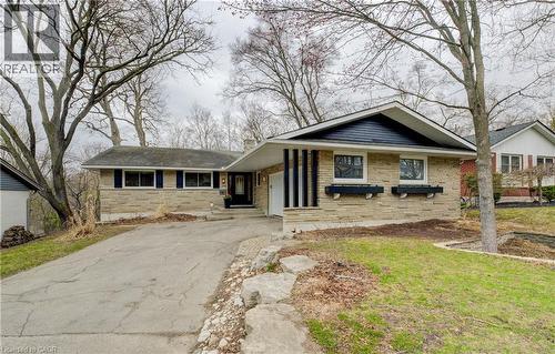 View of front of property with brick siding, a front yard, driveway, and a chimney - 279 Ferndale Place, Waterloo, ON - Outdoor With Facade