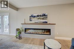 Living room featuring a glass covered fireplace and wood finished floors - 