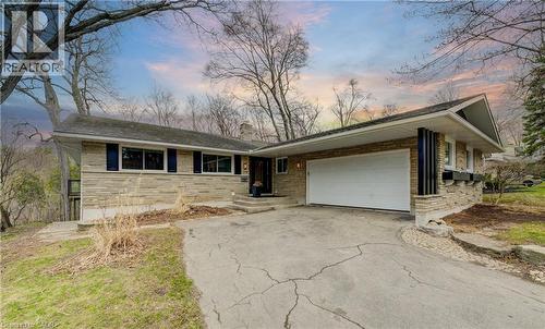 Ranch-style home with asphalt driveway, an attached garage, a shingled roof, stone siding, and brick siding - 279 Ferndale Place, Waterloo, ON - Outdoor