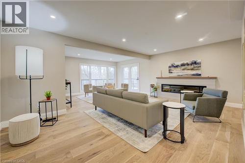 Living room with light wood-style floors, a glass covered fireplace, and recessed lighting - 279 Ferndale Place, Waterloo, ON - Indoor Photo Showing Other Room With Fireplace