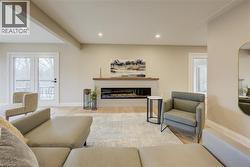 Living area with a glass covered fireplace, wood finished floors, and recessed lighting - 