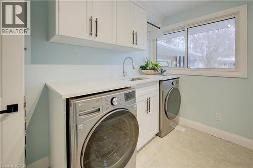 Laundry room featuring washing machine and dryer and cabinet space - 279 Ferndale Place, Waterloo, ON - Indoor Photo Showing Laundry Room