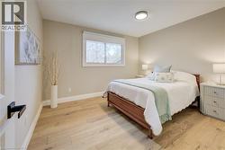 Bedroom with light wood-type flooring and baseboards - 