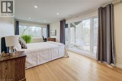 Bedroom with light wood finished floors and recessed lighting - 