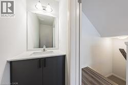 Bathroom with vanity, dark wood finished floors, and lofted ceiling - 