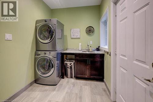 Washroom featuring stacked washer and clothes dryer and baseboards - 1525 Dickie Settlement Road, Cambridge, ON - Indoor Photo Showing Laundry Room