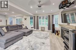 Living area with light wood-type flooring, recessed lighting, a fireplace, and ceiling fan - 