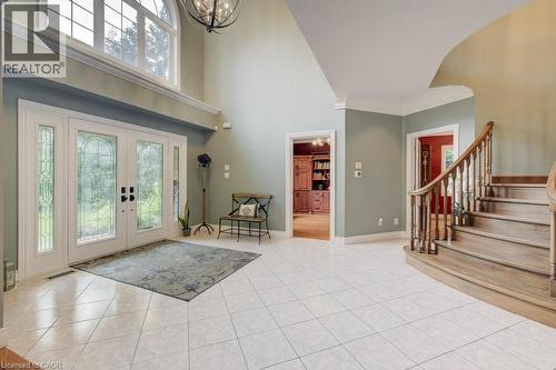 Foyer entrance featuring french doors, stairs, a chandelier, light tile patterned flooring, and ornamental molding - 1525 Dickie Settlement Road, Cambridge, ON - Indoor Photo Showing Other Room
