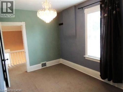 Unfurnished room with a chandelier and light carpet - 134 Courtland Avenue E, Kitchener, ON 