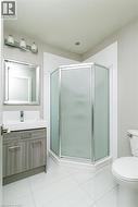 Bathroom featuring a shower stall, vanity, and light tile patterned floors - 