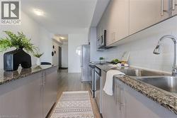 Kitchen with a sink, tasteful backsplash, appliances with stainless steel finishes, and dark stone countertops - 