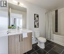Full bathroom featuring tile patterned flooring, toilet, vanity, and shower / tub combo with curtain - 
