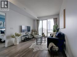 Living area with baseboards, a textured ceiling, and wood finished floors - 