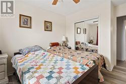 Bedroom with wood finished floors, a closet, baseboards, and a ceiling fan - 